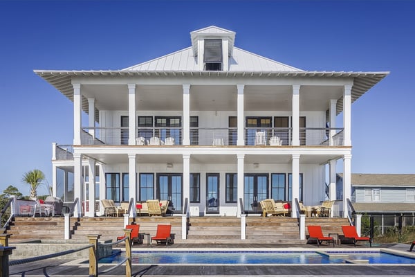 WHite wood beach home with a pool